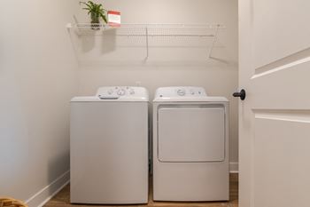 a washer and dryer in a laundry room  at Century West Pryor, Missouri
